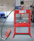Boss Level 10 Ton H Frame Hydraulic Shop Press With Adjustable Base And Steel Plates For Heavy Duty Garage Workshop And Auto Repair Quick Release Cylinder Pump in a workshop with visible hydraulic pump.