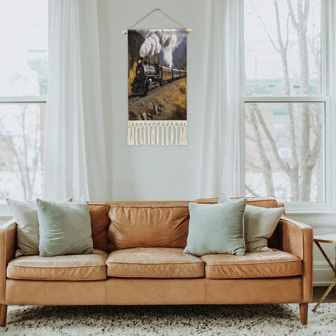 Dope Locomotive Train Wall Tapestry With Tassels Cotton And Linen Hanging Poster displayed in a living room above a sofa.