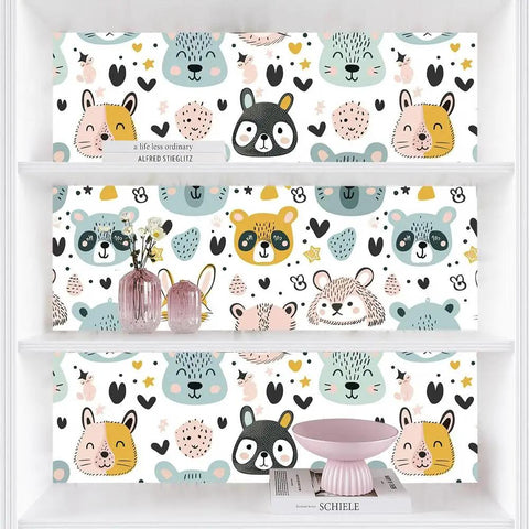 Slick Pastel Woodland Peel And Stick Wallpaper With Cute Animal Head Prints displayed on shelves, perfect for playrooms.