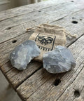 English Flint Fire Starter Kit with two UK flint stones on rustic wood table and emergency jute tinder bag for bushcraft camping and survival.
