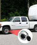 Close-up of 2.75 Inch Trailer Hub Bearing Dust Caps Kit With 4 Pack Rubber Plugs next to a white truck and trailer