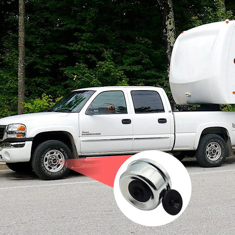 Close-up of 2.75 Inch Trailer Hub Bearing Dust Caps Kit With 4 Pack Rubber Plugs next to a white truck and trailer
