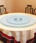 Heavy Duty Tempered Glass Lazy Susan Rotating Serving Plate on a round table with a smooth aluminum swivel base.