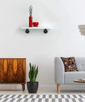 Living room with a wall-mounted shelf supported by a Half Inch Pipe Shelf Bracket Set Of 4 For Wall Mounted Floating Shelves Industrial Rustic Decor.