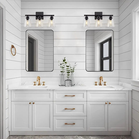 Three Light Black Vanity Lights Over Mirror in modern farmhouse bathroom with clear glass shades above double sink vanity.