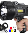 Ultra Bright Rechargeable Spotlight 2,000,000 Lumens LED Handheld Flashlight with 3 color lenses and foldable stand in hand.