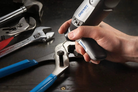 Variable Speed Corded Rotary Tool Kit For DIYers with wrench and pliers on a workbench.
