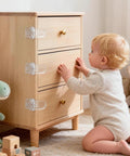 Toddler reaching for drawers secured with Six Pack Clear Baby Drawer Locks Zero Sweat Install Keep Little Rascals And Fur Babies Locked Out.