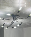 Black Sputnik Ceiling Light Fixture With Eight Adjustable Arms Industrial Semi Flush Mount Chandelier lit up on ceiling