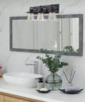 24-Inch 3-Light Modern Farmhouse Vanity Light With Hanging Lantern Style And Seeded Glass Shades In Bold Black Finish in a bathroom.