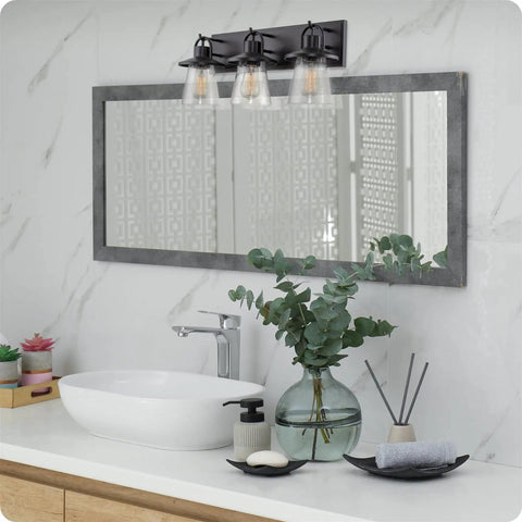 24-Inch 3-Light Modern Farmhouse Vanity Light With Hanging Lantern Style And Seeded Glass Shades In Bold Black Finish in a bathroom.