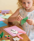 Child using 1/4 Inch Circle Hole Punch Handheld Paper Punch with Grip Handle for easy crafts and scrapbooking projects at home.