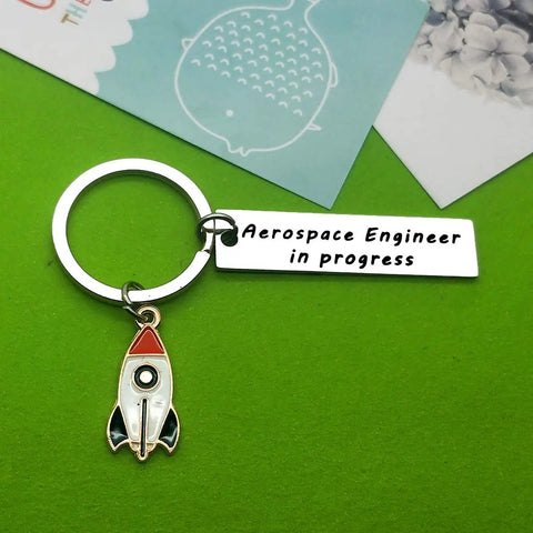 Funny Aerospace Engineer Keychain Gift For Graduation And Appreciation with rocket charm on green background