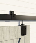 Heavy Duty Outdoor Sliding Barn Door Hardware Kit For Exterior Use With 450 Lb Capacity Black Powder Coated Finish Built To Endure Outdoor Weather Tough As Nails Fits Two Doors Up To 144 Inches Wide, close-up installation view showing black hardware on wooden door.