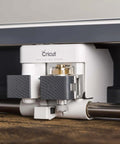 Cricut knife blade and drive housing installed under the Cricut Maker; white unit with gray A and B tool blocks.