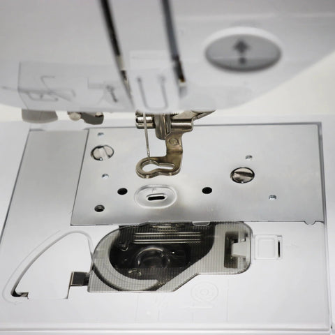 Front view bobbin cover plate on white sewing machine with presser foot