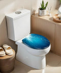 Elongated Blue ocean waves from underwater bubbles Toilet Seat atop a modern white toilet in a bright bathroom.