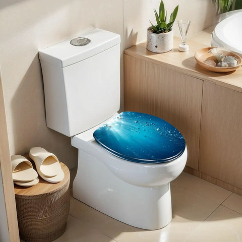 Elongated Blue ocean waves from underwater bubbles Toilet Seat atop a modern white toilet in a bright bathroom.