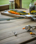 Stainless Steel Archery Arrowheads Set 8 Piece Judo Broadheads for Hunting and Small Game on wooden table with fishing gear.