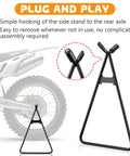 2 Pack Dirt Bike Triangle Stands For Rear Wheel Maintenance Stand Beefy Solid Steel Construction Fits 80cc To 500cc Dirt Bikes Motocross Supermoto Black With Anti Slip Feet For Stable Setup And Easy Storage In Garage Or Shop shown with plug and play design next to bike rear wheel.