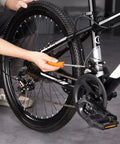 Person using tool on bicycle chain mechanism inside workshop