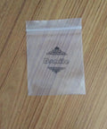 Clear plastic ziplock bag with decorative text on a wooden surface