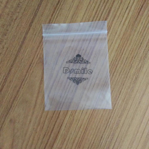 Clear plastic ziplock bag with decorative text on a wooden surface