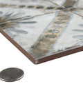Close-up of Harmonia Marrakech Blue 13x13 Ceramic Tile For Floor And Wall Use beside coin for thickness comparison.
