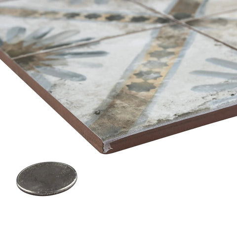 Close-up of Harmonia Marrakech Blue 13x13 Ceramic Tile For Floor And Wall Use beside coin for thickness comparison.