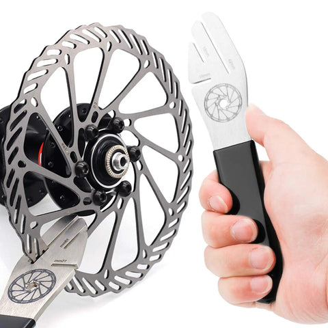 Close-up of hand using Bike Disc Rotor Alignment Tool For No Fuss Rotor Truing And Quick Bike Wheel Alignment on a rotor.