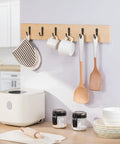 10 Pack Wall Hooks For Bathroom Kitchen Closet And Garage Black Metal Hangers That Hold Up To 40 Lbs Ultra Strong Built To Last installed on wall holding kitchen items like cups, towel, and utensils.