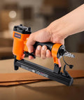 Pro Grade Pneumatic Staple Gun For Woodworking And Upholstering Projects Featuring Slick Firing 22 Gauge Design in hand on workspace.