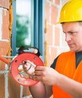Wxtools 100 Ft Fish Tape For Electric Wire Pulling Reel With Durable Handle and Thumb Lock used by a worker in a construction setting.