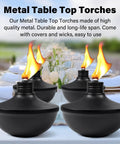 Four black metal tabletop torches lit on a table, part of Six Pack Upgraded Tabletop Citronella Torches With 24 Oz Fuel Capacity Refillable Outdoor Torch Lights Includes Wicks Covers And Funnel Party Ready For Garden Patio Deck Yard And Landscape set.