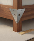 Beefy Stainless Steel Heavy Duty Corner Brace Triangular L Bracket mounted on wood bed frame corner for reinforcement
