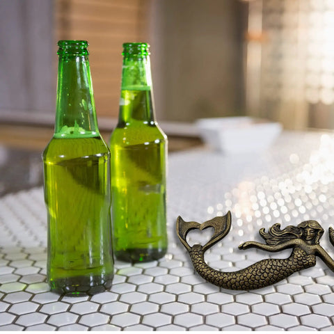 Heavy Duty Cast Iron Mermaid Bottle Opener For Beach House Kitchen Decor, Totally Rad Nautical Bar Essential, Thick Cast Metal Cap Lifter With Killer Coastal Design, Seven Inches next to two green bottles.