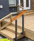Adjustable Wooden Railing Kit For Outdoor Steps And Porch With Dang Tough Wrought Iron Brackets and sleek posts installed on wooden steps.