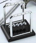 Five Ball Newton's Cradle Desktop Toy For Office And Home Decor With Black Wood Base And Strong Nylon String on a desk
