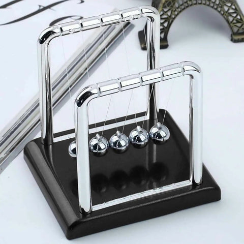 Five Ball Newton's Cradle Desktop Toy For Office And Home Decor With Black Wood Base And Strong Nylon String on a desk