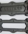 Neo Classical Cast Iron Mailbox With Swinging Letter Slot Door Wall Mounted Vintage Antique Postal Box Old School Charm, Ornate Garlands And Floral Accents, Reproduction Of 1900 Original With Weathered Iron Finish; close-up of letter slot design