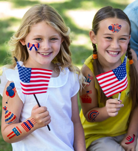 Two girls holding USA flags, wearing 4th Of July Women Outfit Set With 120 PCS USA Flag Temporary Tattoos for a festive vibe.
