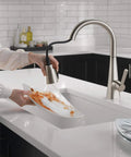 Crisp Brushed Nickel Kitchen Faucet Featuring Heavy Duty Pull Down Sprayer in action rinsing a plate in a modern kitchen.
