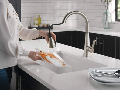 Crisp Brushed Nickel Kitchen Faucet Featuring Heavy Duty Pull Down Sprayer in action rinsing a plate in a modern kitchen.