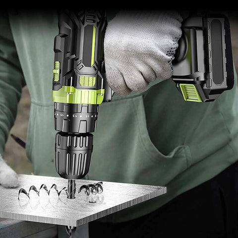 Cordless power drill with tungsten carbide masonry bit drilling into a metal sheet; green and black tool with battery pack.