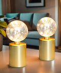 Large Cage Table Lamp Battery Powered With Double Metal Mesh And Edison Bulbs 8W X 10H on a table with glowing bulb effect.