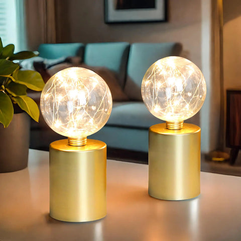 Large Cage Table Lamp Battery Powered With Double Metal Mesh And Edison Bulbs 8W X 10H on a table with glowing bulb effect.