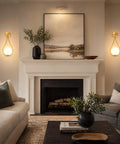 Lit Mid Century Modern Wall Sconces Set Of 2 With Globe Glass Shades In Antique Brass Finish in living room above fireplace.