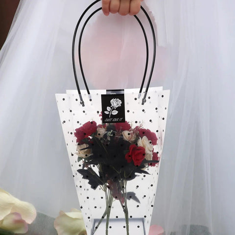 Person holding Plastic Flower Bouquet Bag With Handle For Floral Arrangements And Weddings, containing roses, transparent with polka dots