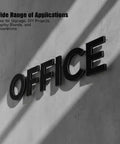 Black office sign letters mounted on a concrete wall with diagonal shadows.