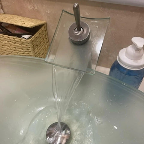 Squared Single Lever Waterfall Vessel Faucet In Brushed Nickel With Clear Glass, water flowing into sink